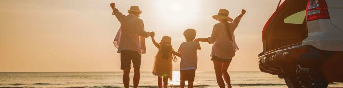 Happy family travelling by car to the beach