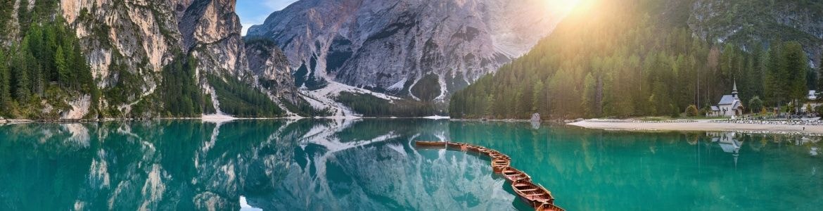 Lago cristalino rodeado de montanhas em Di Braies
